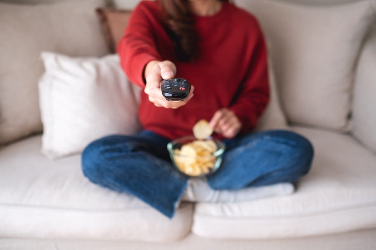 closeup image of a woman eating potato chips while searching cha