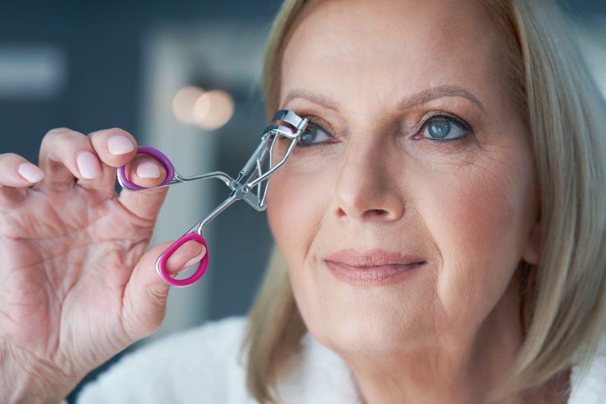 senior woman applying makeup in the bathroom