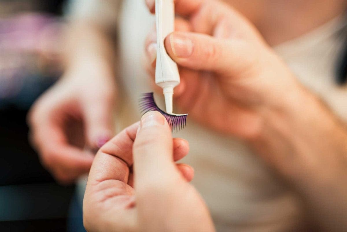 Applying adhesive to false eyelashes
