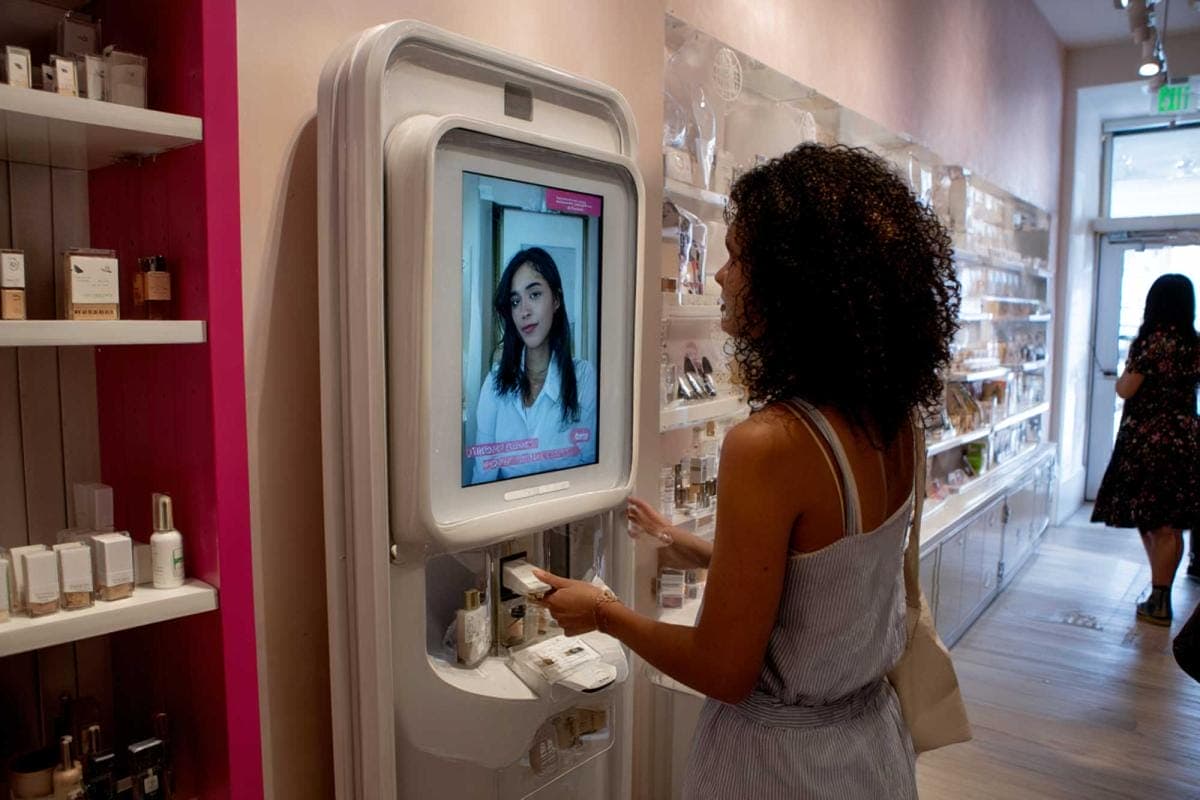 Woman using makeup vending machine in store