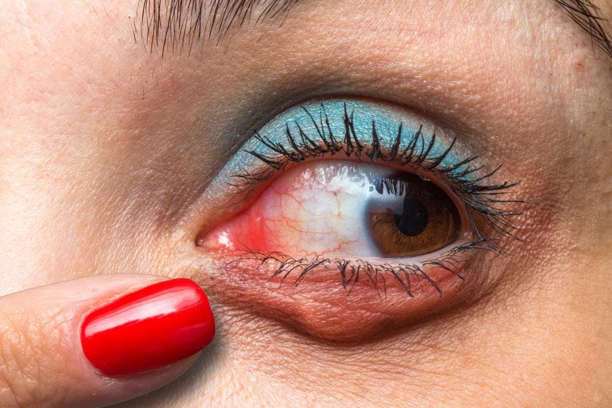 Close-up of irritated eye with red makeup