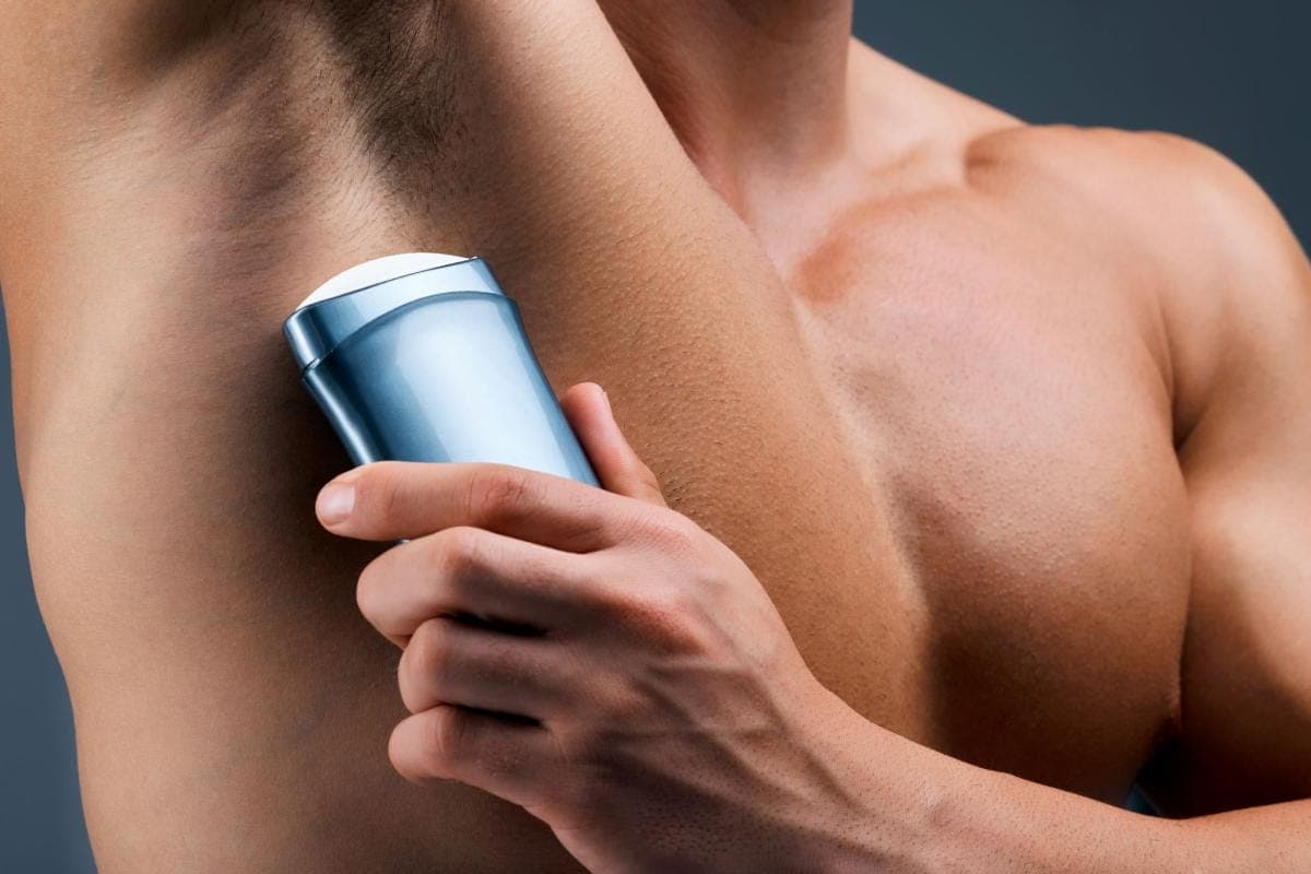 Man applying deodorant underarm
