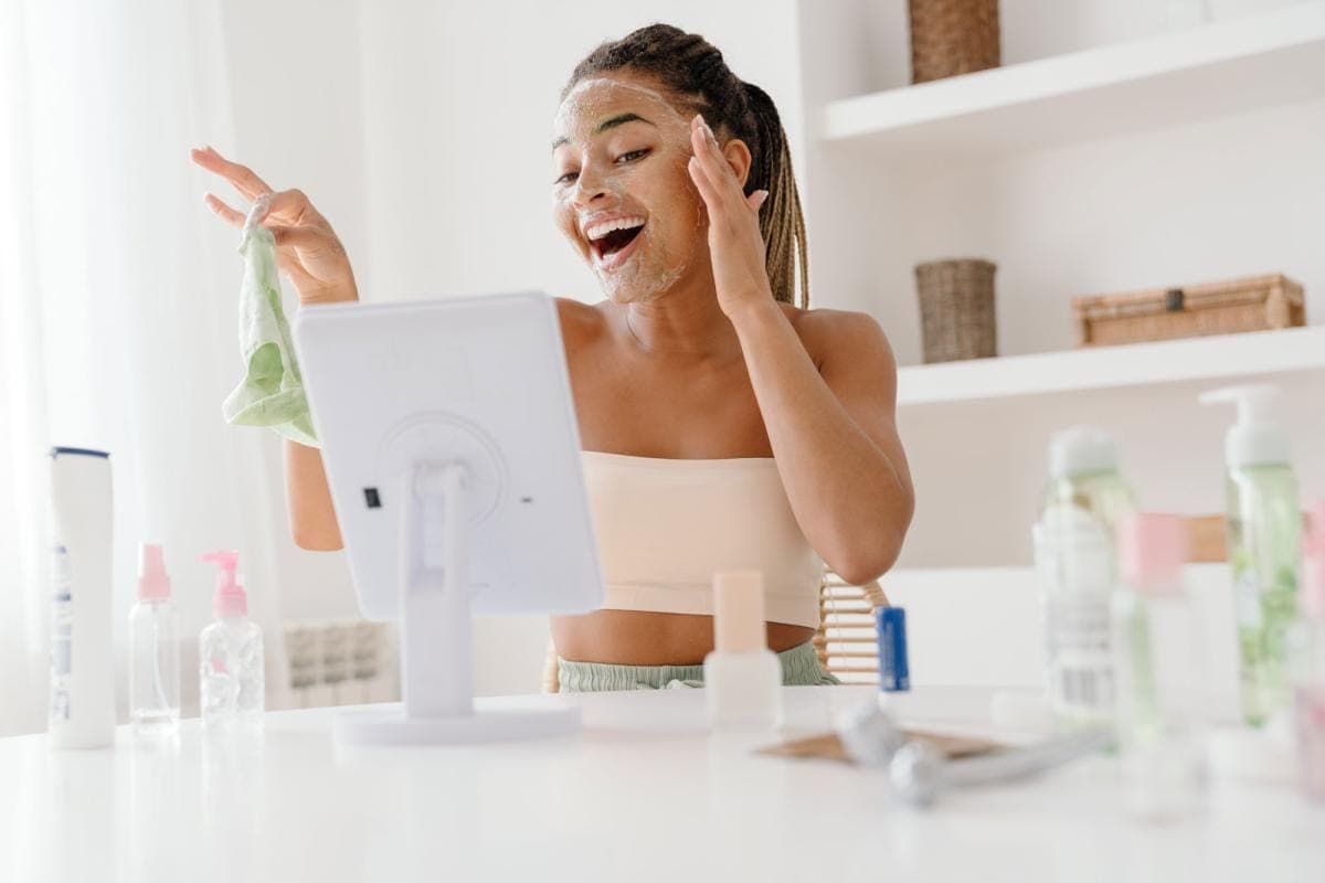Woman with facial mask using skincare products