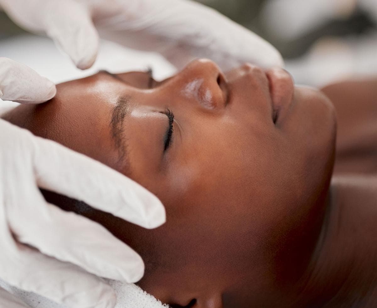 Person receiving relaxing facial massage with gloves