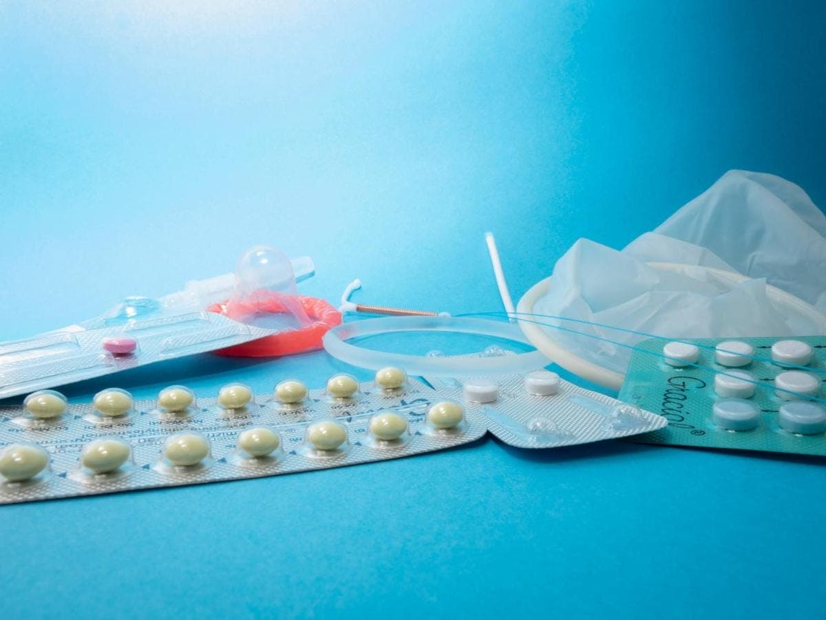 Various contraceptives on blue background.