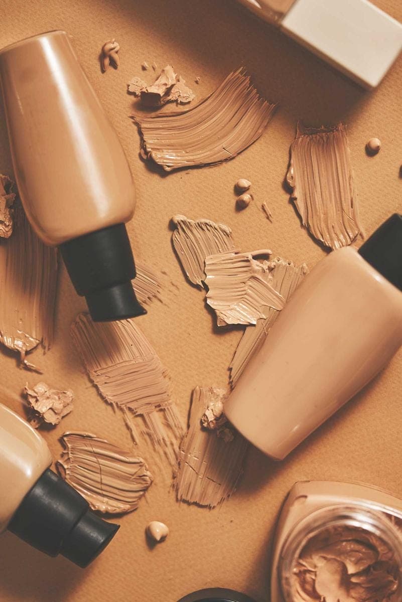 Assorted makeup foundation bottles and swatches.